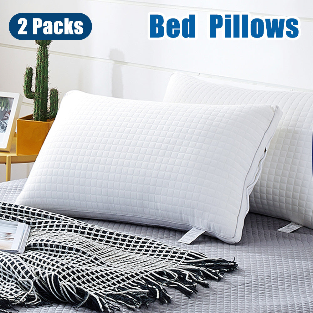 Set of two white quilted bed pillows stacked on a textured blanket