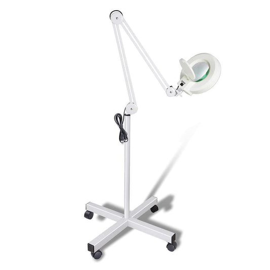 Magnifying floor lamp with white wheeled base and glass magnifier lens light head