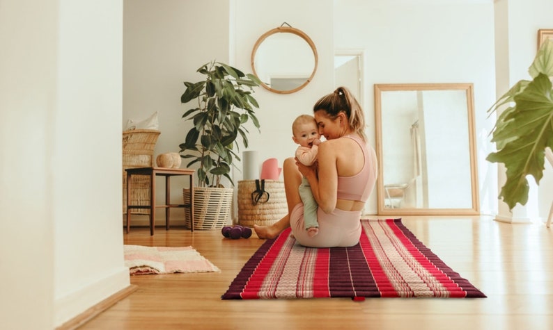 Foldout roll-out mattress with red and dark striped cover, flat open surface