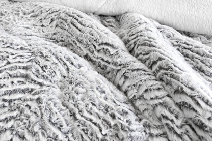 Light gray faux fur sherpa comforter with plush textured surface, close-up