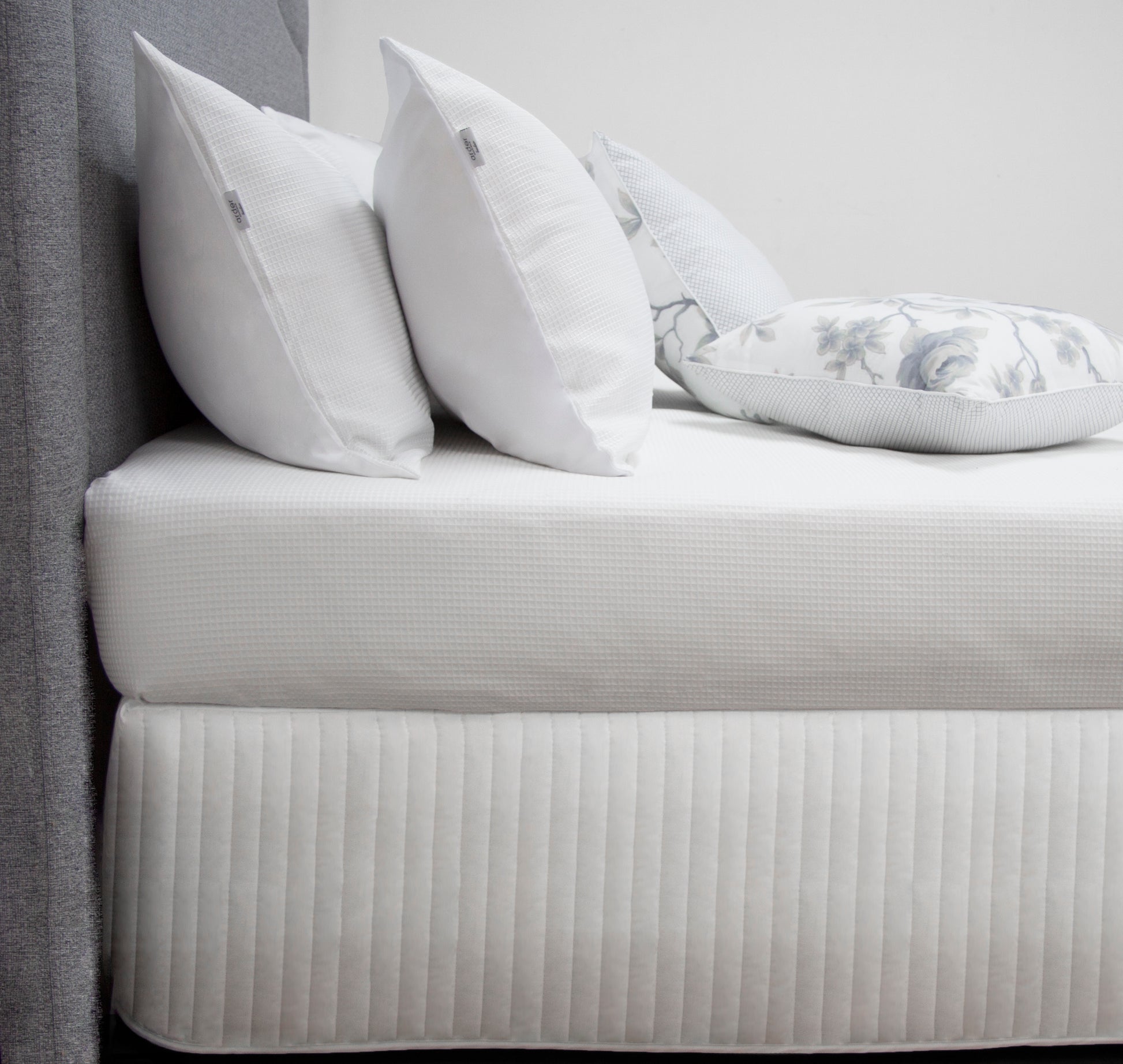 Quilted bed valance in white with stitched channel pattern and straight drop