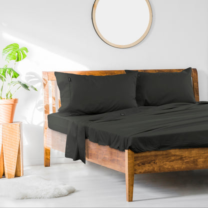 Black king sheet set with pillowcases and fitted flat sheet on wooden bed