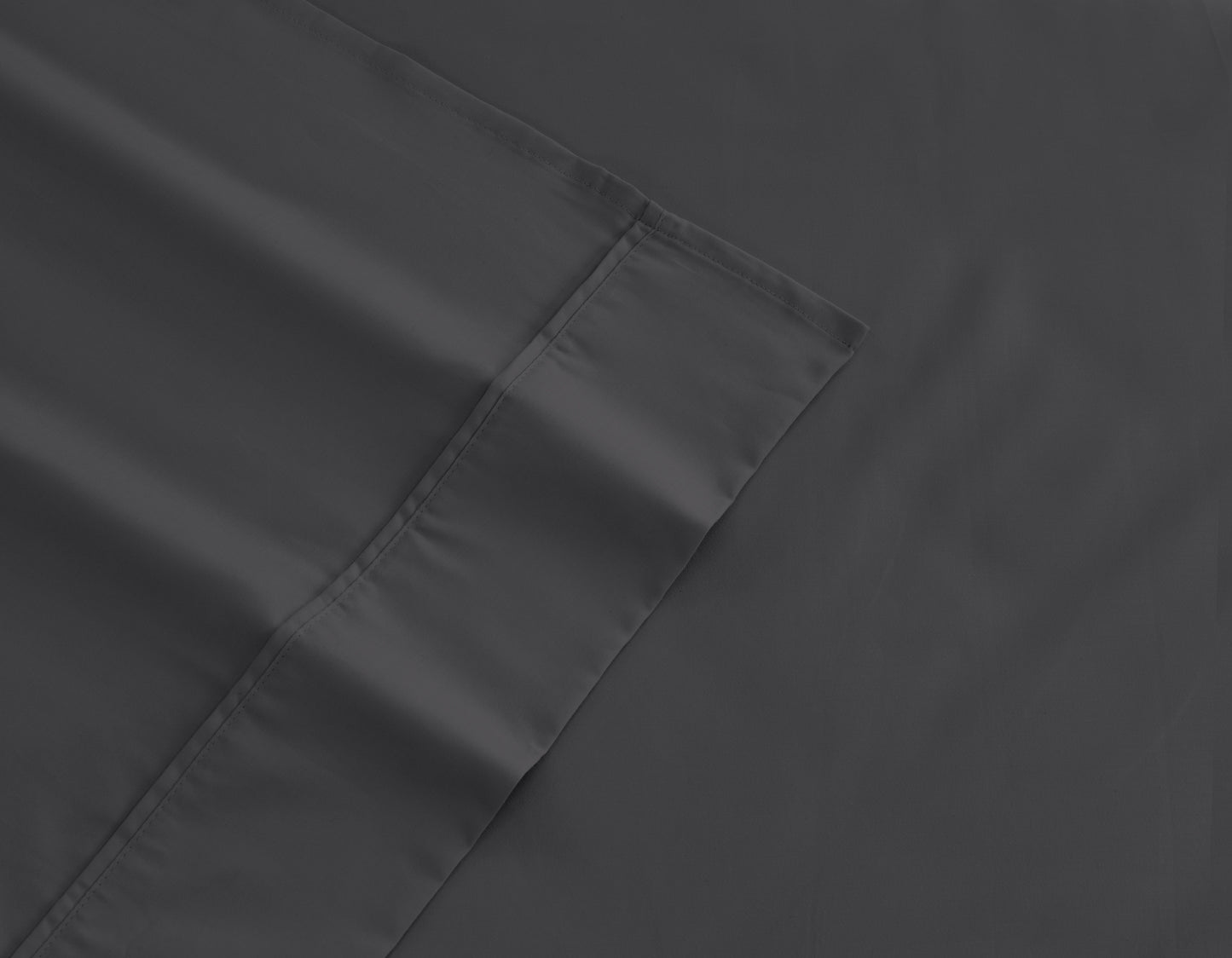 Dark gray fitted sheet corner with double-stitched hem and seam detail