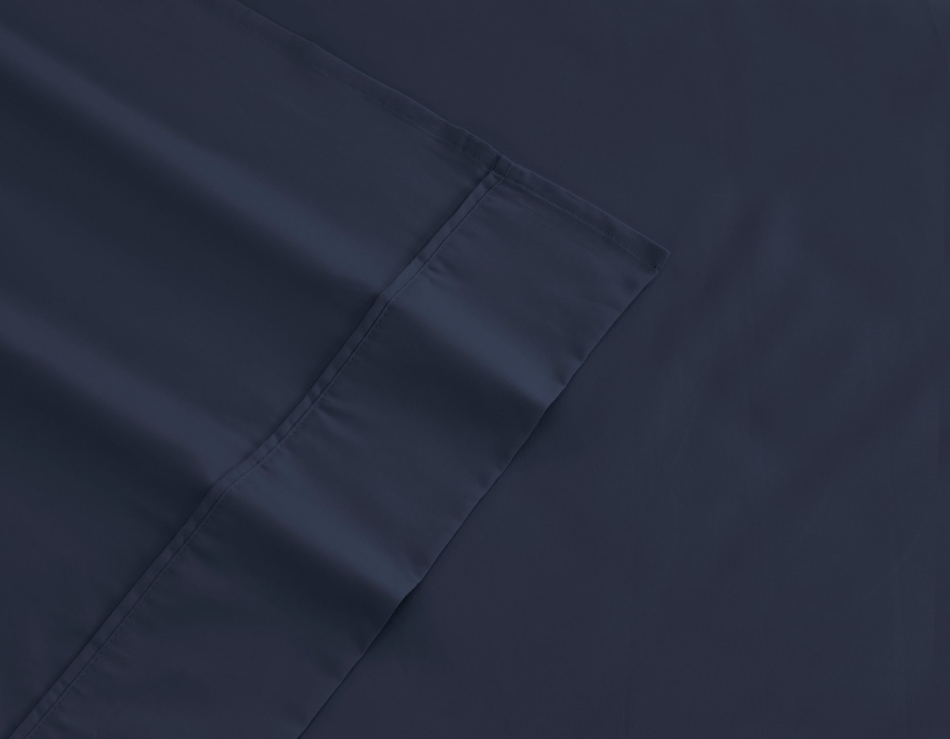 Navy cotton sheet fabric close-up with stitched seam