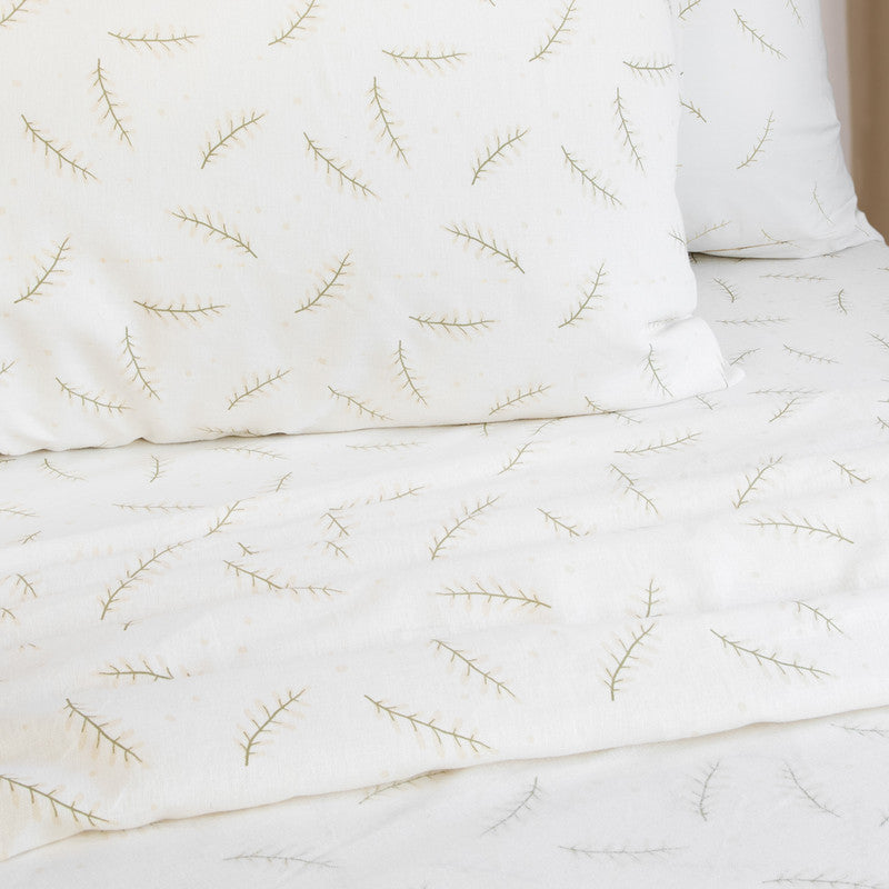 Single sheet set with white fabric and green branch embroidery, folded and creased