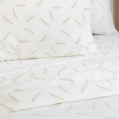 Single sheet set with white fabric and green branch embroidery, folded and creased