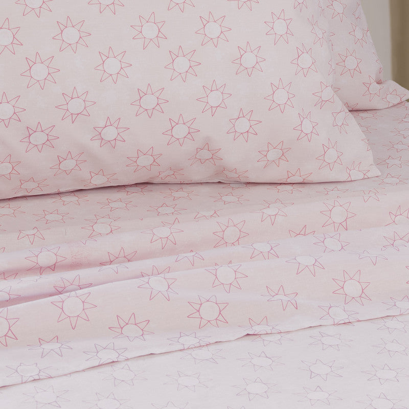 Pink sheet set with small starburst pattern, folded seam visible