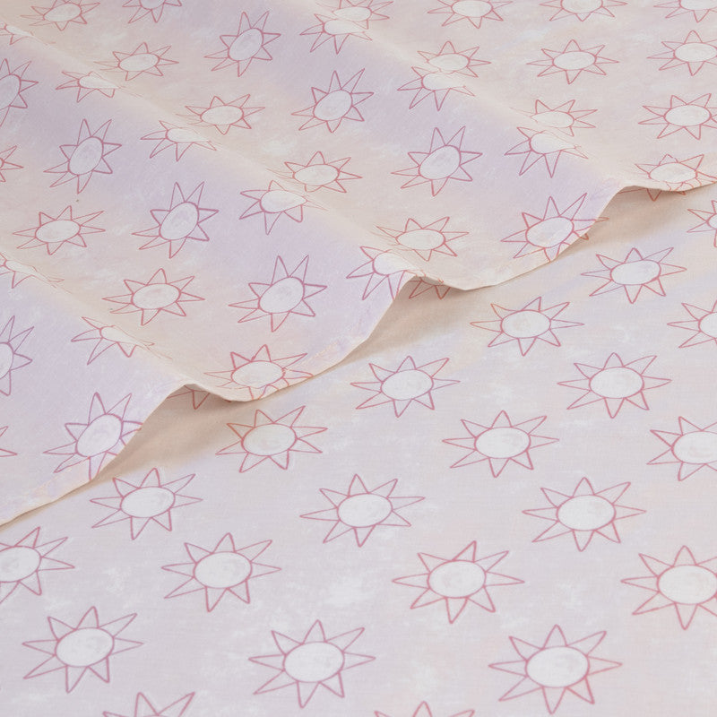 Single sheet set fabric close-up with pale pink star pattern and soft folds