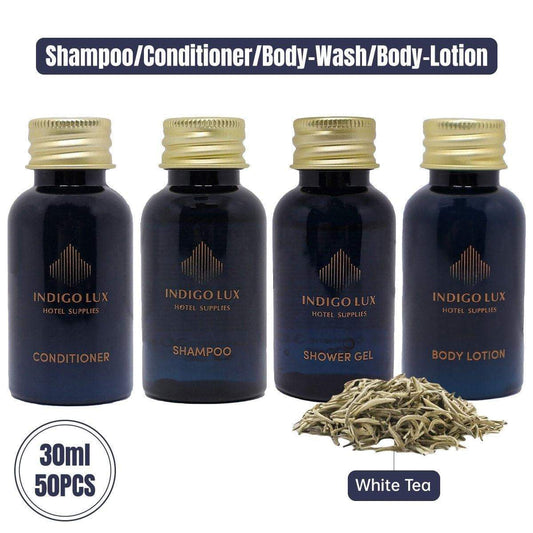 Hotel toiletries set with four dark bottles: conditioner, shampoo, shower gel, body lotion