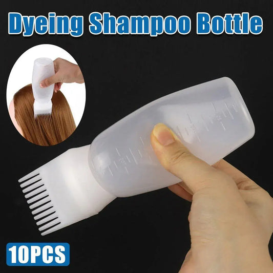 Squeeze dye bottle with comb applicator tip and measuring marks, held in hand