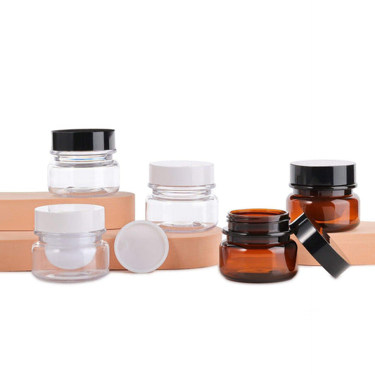 Assorted refillable cream jars with black and white lids; clear and amber PET containers