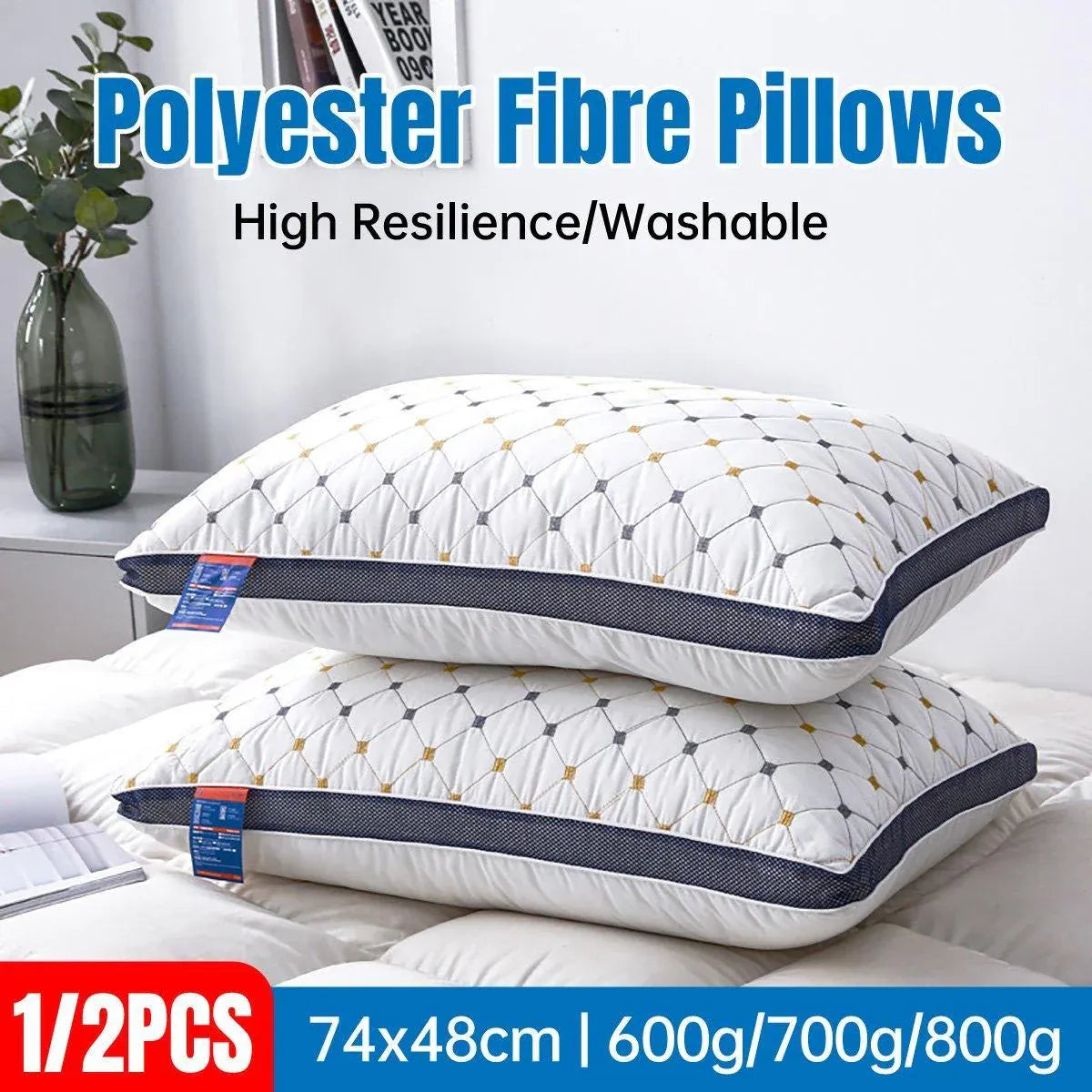 Two white pillows with blue stitching on a bed, labeled as polyester fibre pillows with high resilience and washability.