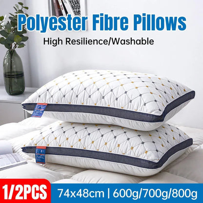 Two white pillows with blue stitching on a bed, labeled as polyester fibre pillows with high resilience and washability.