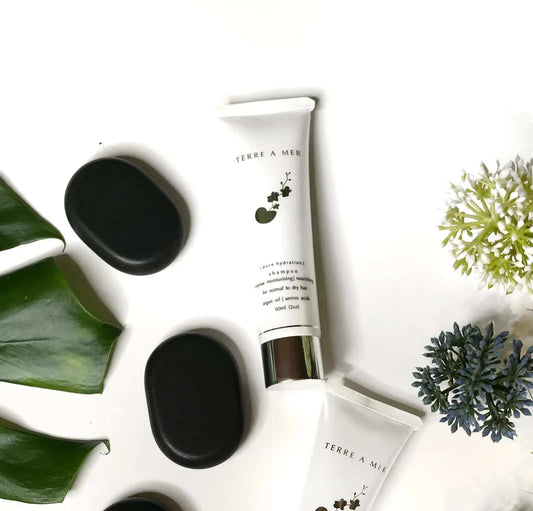 Terre A Mer shampoo tubes with caps, white bottles with black flower accents