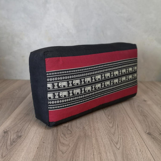 Oblong yoga bolster cushion with dark navy and red panels, patterned trim.