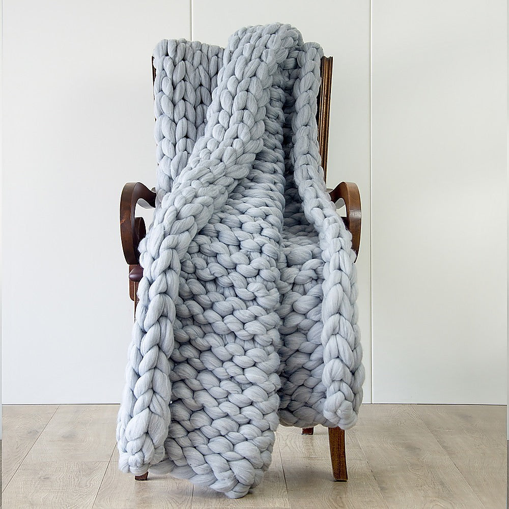 Chunky knit blanket in light grey, thick looped weave with layered drape