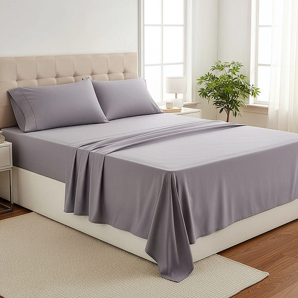 Grey king bed sheet set with fitted sheet and two pillowcases on a bed