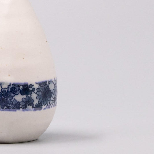 White ceramic vase with blue floral wrap around lower section