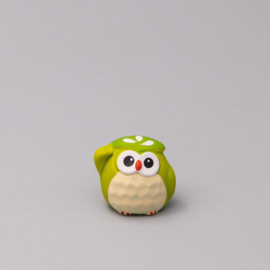 Green owl figurine with round white belly and painted face