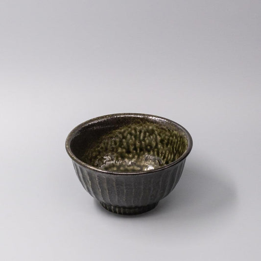 Ceramic bowl with dark moss green and black glaze, ribbed texture and flared rim