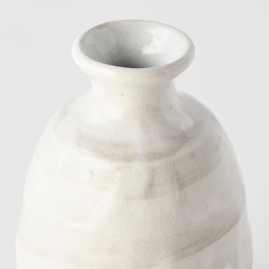 White glazed ceramic sake jug close-up of rounded body and flared rim opening