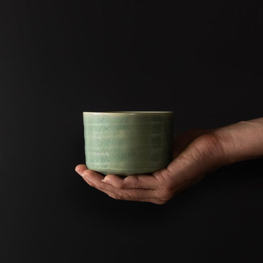 Jade green ceramic matcha tea bowl with wide rim and crackle glaze