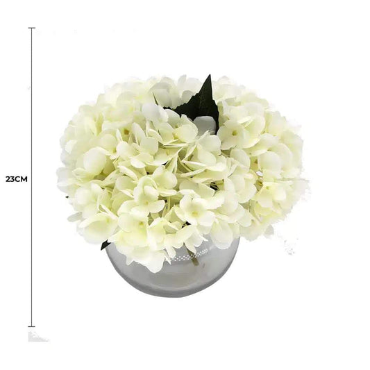 Artificial white hydrangea in gray glass vase, full bouquet view with dark leaves