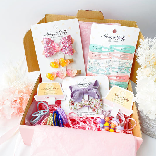 Kids surprise hamper box with pink bows, hair clips, and colorful accessories