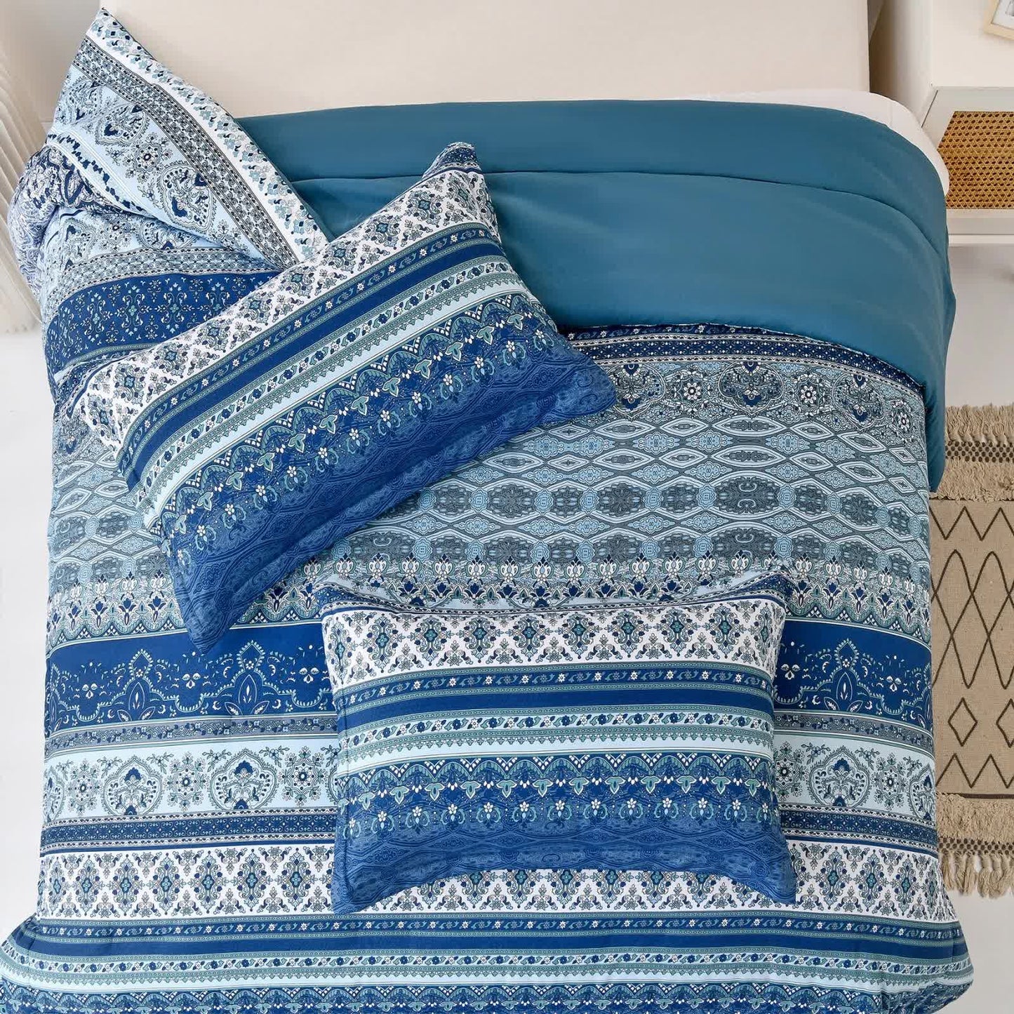 Boho bedding set with blue comforter and multiple patterned pillow covers on bed
