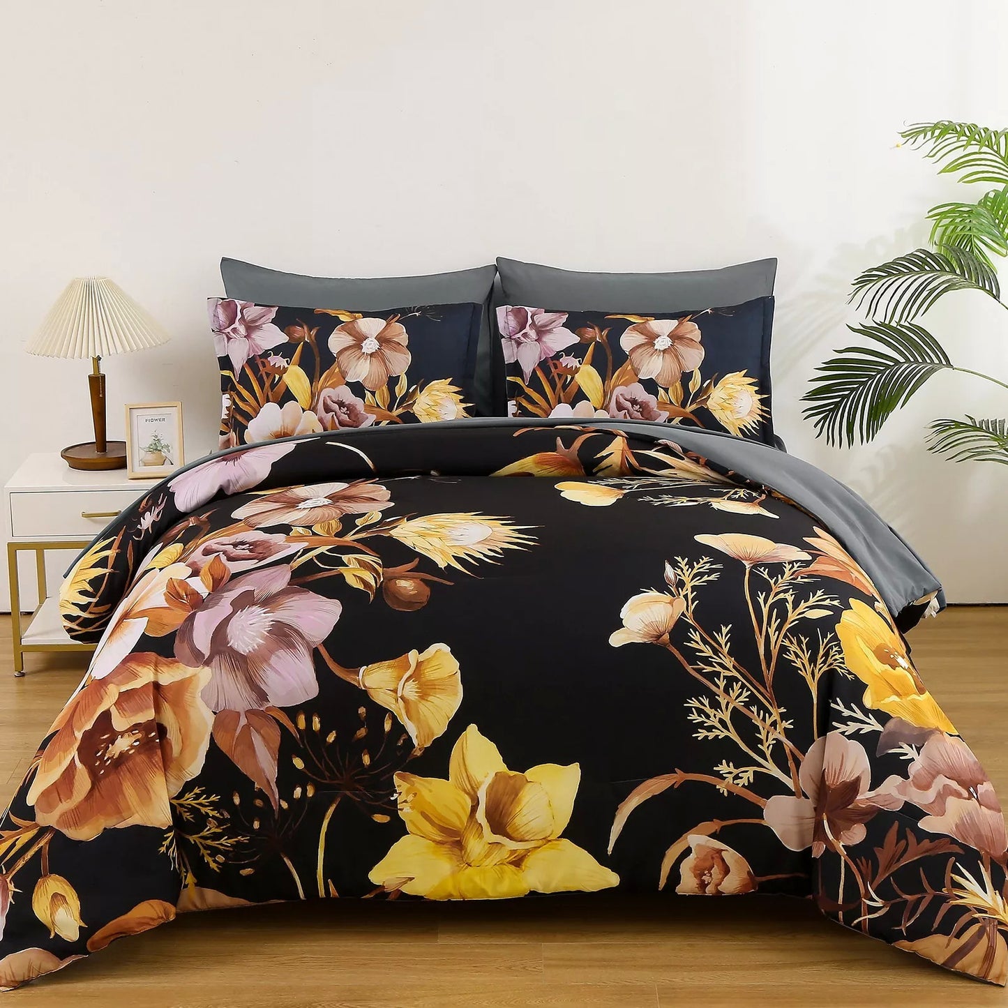 Quilted bedding set with black floral comforter, gray accents, and two patterned pillows
