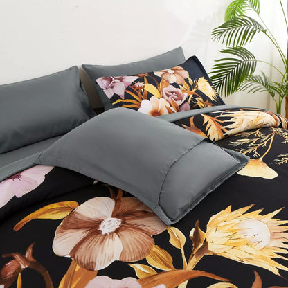 Quilted comforter set with black floral print, gray pillows, and folded duvet