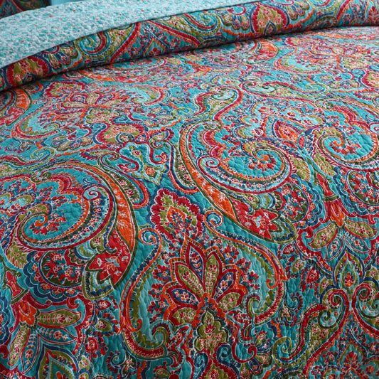 Teal paisley quilt bedspread with intricate red, orange, and green ornamental pattern