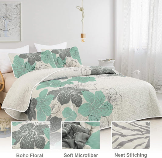 Quilted coverlet and pillow shams with large teal, gray, and white leaf floral print