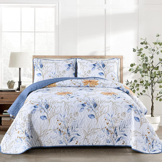 Floral quilt coverlet with light base, blue leaves and tan flowers, plus two matching pillows