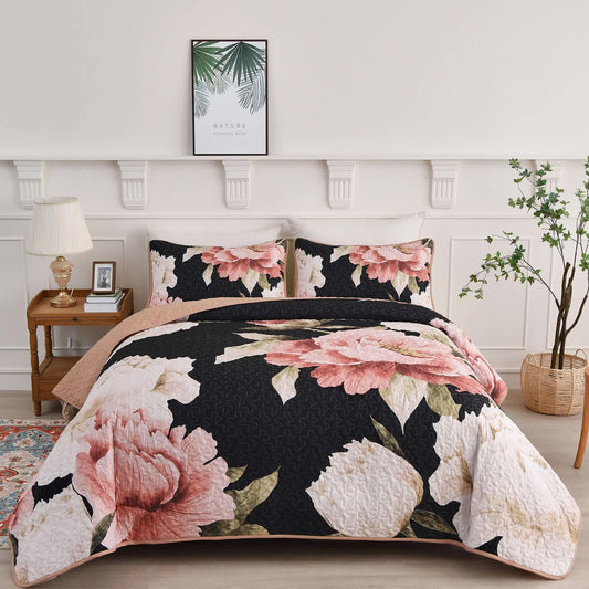 Quilted coverlet set on bed with two black-and-pink floral pillowcases