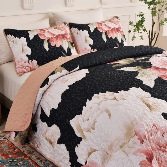 Quilted coverlet with black floral design, pink rose blooms, and matching pillowcases