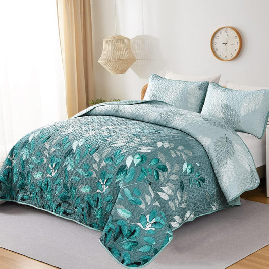 Teal and light blue quilted bedspread set with leaf print and two pillows