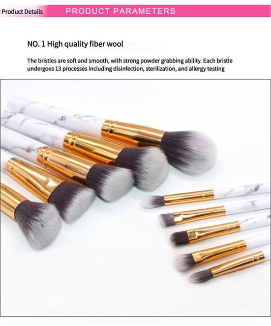 Makeup brushes with white marble handles, gold ferrules, soft gray bristles, angled view