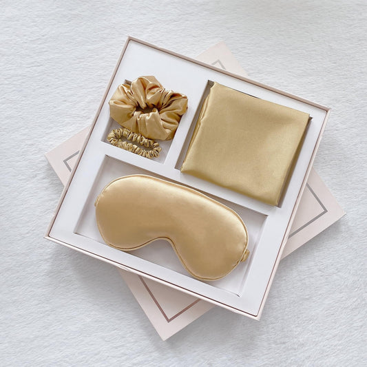 Satin sleep mask gift set with gold eye mask, pillowcase, and matching hair scrunch