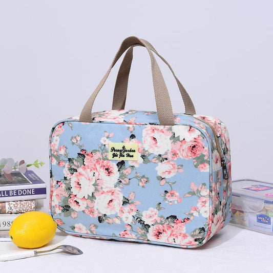 Light blue floral zip-top handled bag with tan handles, waterproof-style fabric