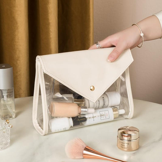 Cream envelope makeup bag with gold snap, clear waterproof front pocket, carry handles
