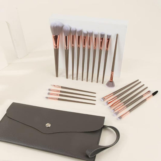 Makeup brush set with taupe handles and rose-gold ferrules, with dark travel pouch