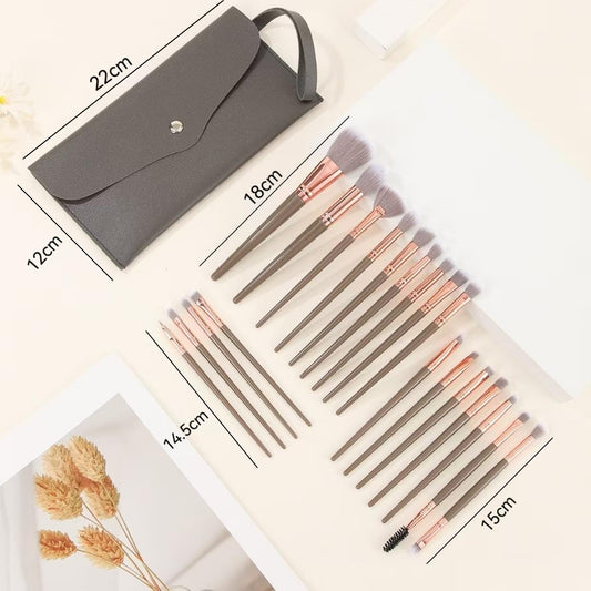 Makeup brush set with dark gray travel pouch and multiple taupe-handled brushes