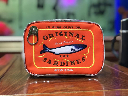 Novelty sardine tin clutch in orange PU leather, metal clasp and label front