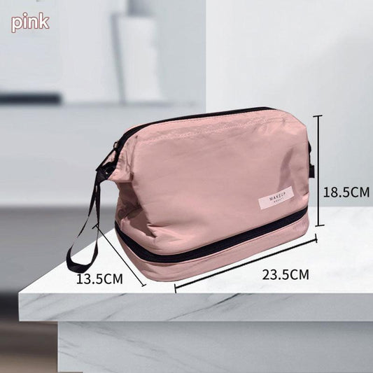 Pink makeup toiletry bag with black trim, top zipper, and side wrist strap.