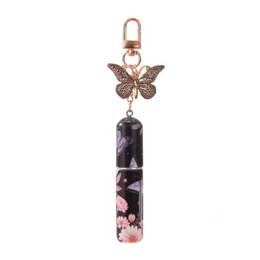 Refillable perfume atomizer keychain with butterfly charm and dark floral spray bottle