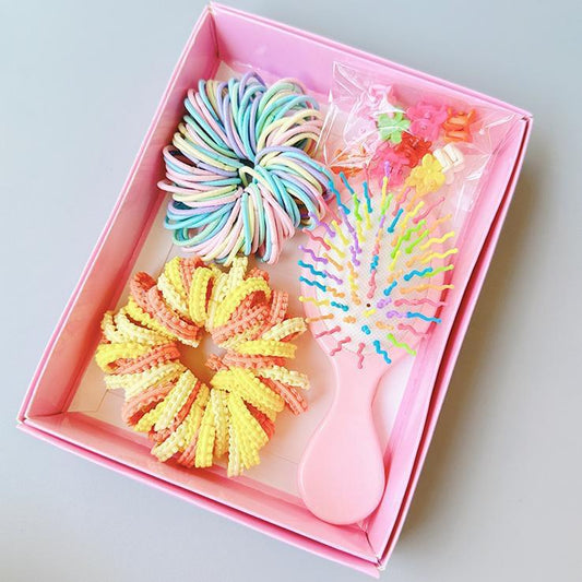 Boxed hair tie set in pink with rainbow scrunchies, flower ties, and mini comb