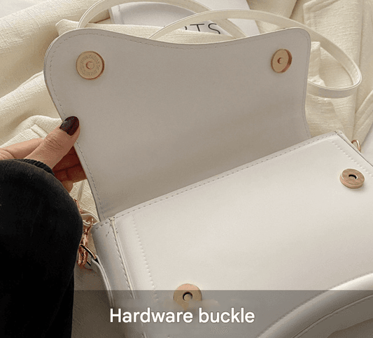 White minimalist crossbody bag with top flap, gold snap hardware, adjustable strap