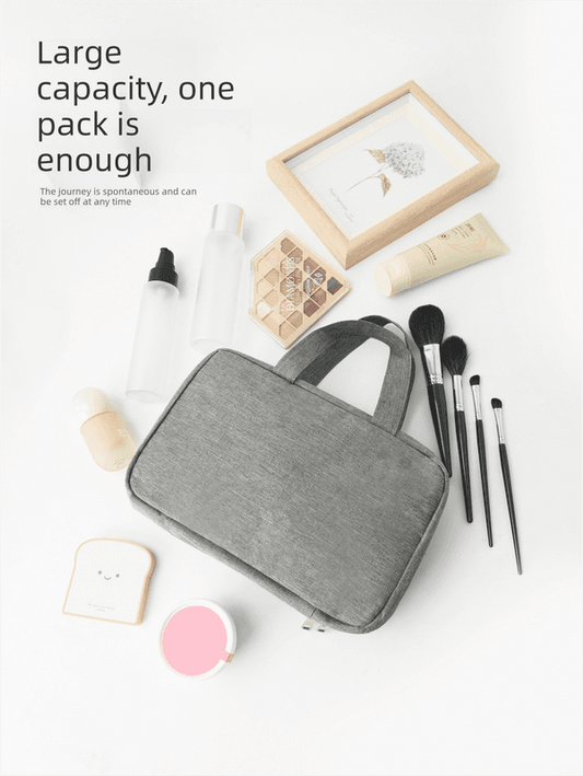 Gray zip toiletry bag with top handle and open layout for toiletries and cosmetics