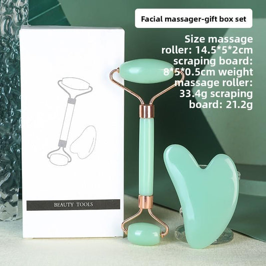 Mint green resin facial roller and heart gua sha, gold-tone handles.